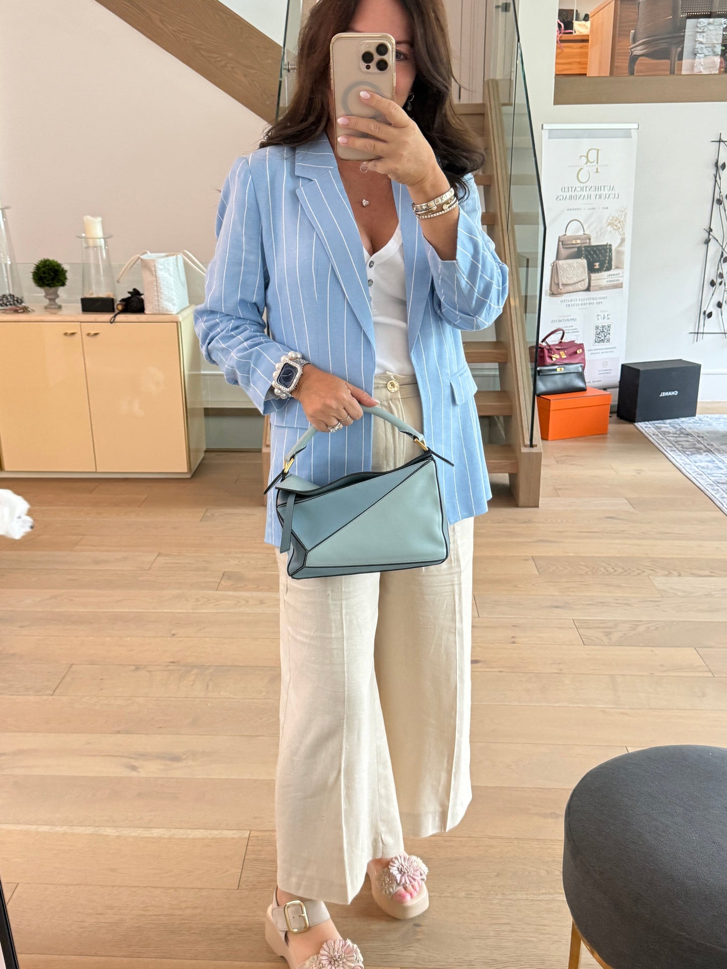 Loewe small puzzle bag in blue shown carried by top handle by woman