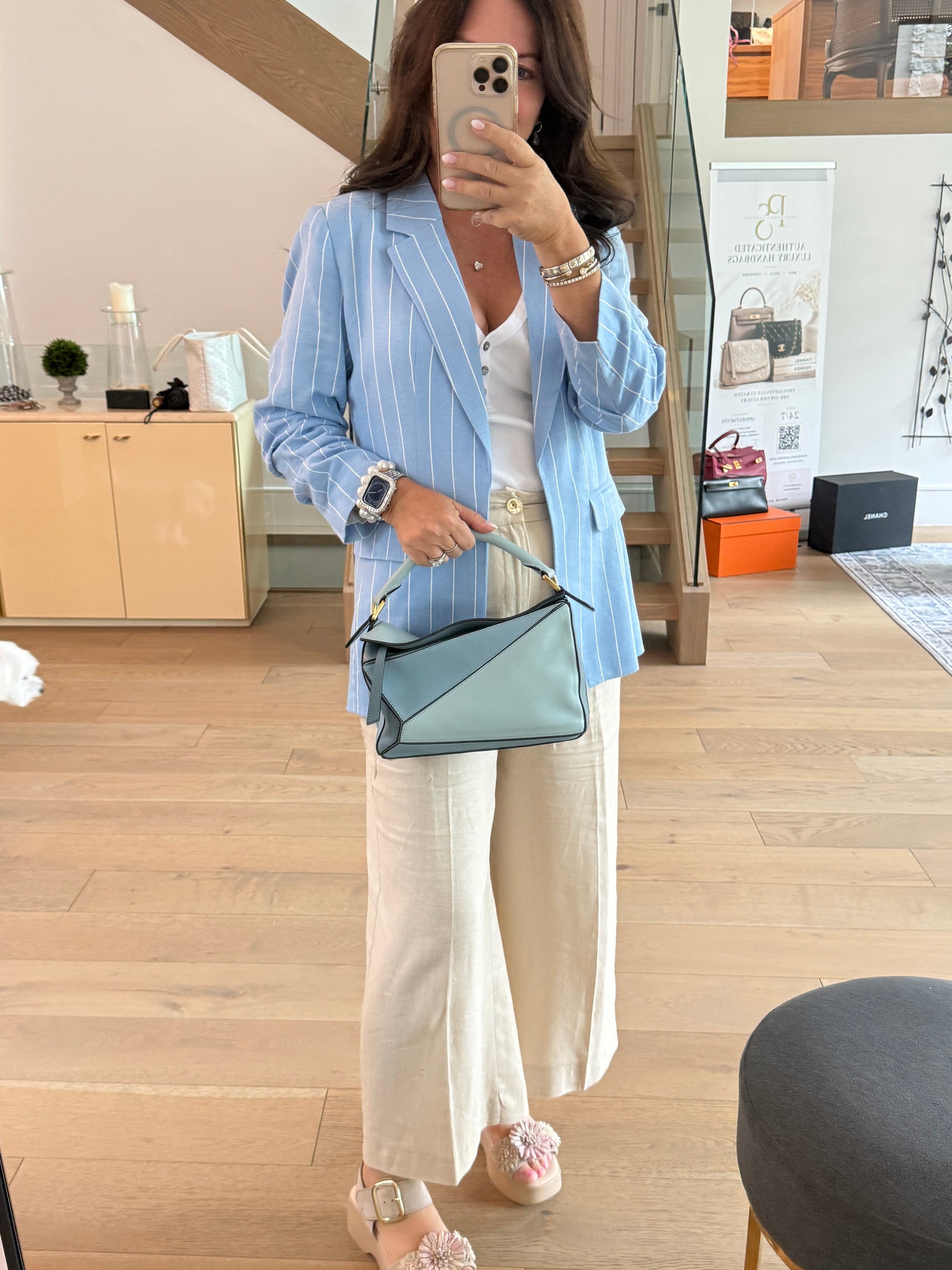 Loewe small puzzle bag in blue shown carried by top handle by woman
