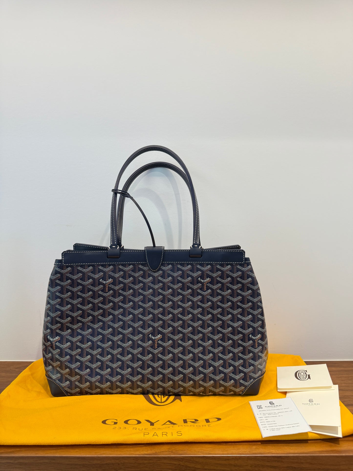 Goyard handbag on a white background with a dustbag Goyard bag in like new condition on consignment and offered for sale from purseonalshopper 