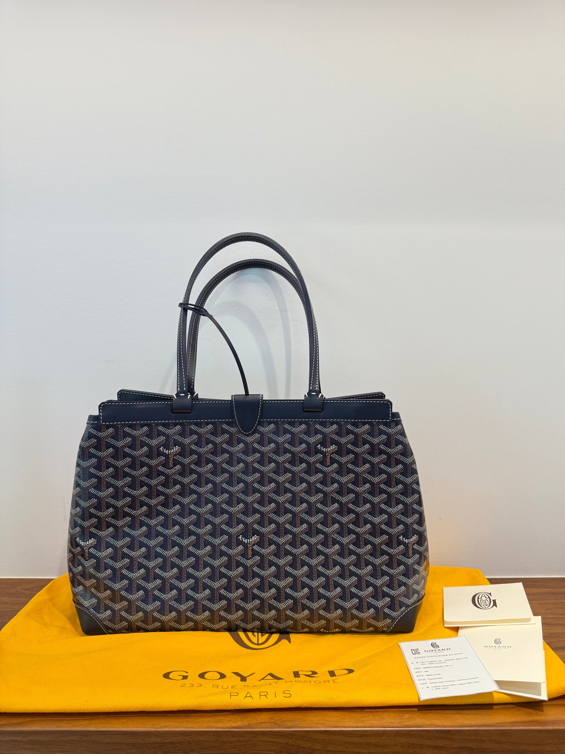 Goyard handbag on a white background with a dustbag Goyard bag in like new condition on consignment and offered for sale from purseonalshopper 