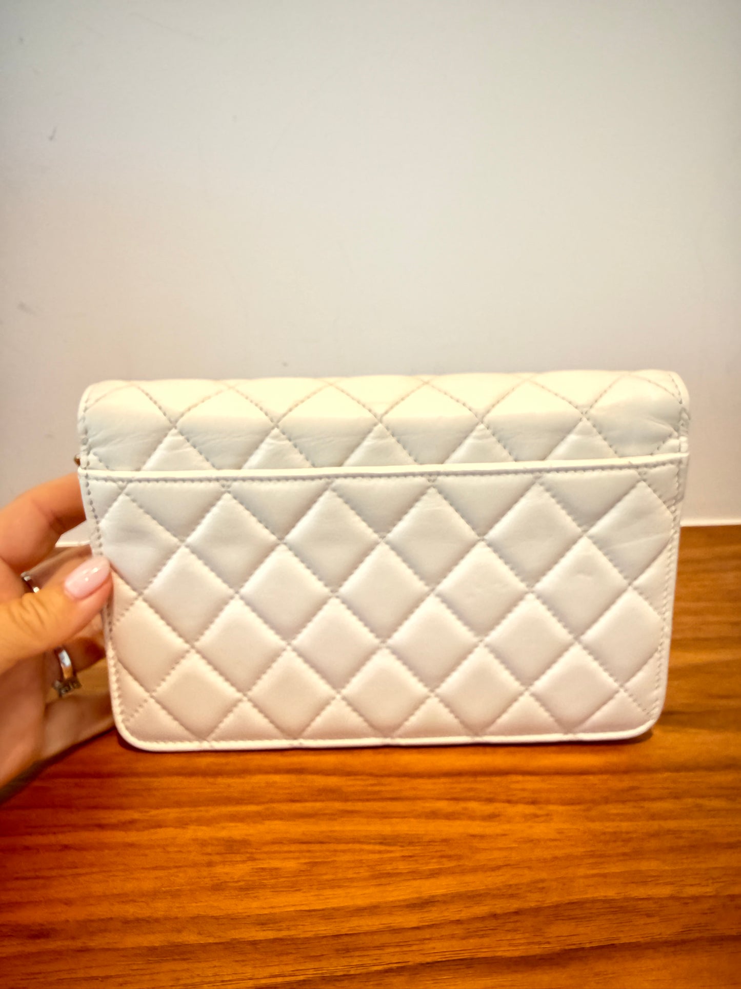 Chanel wallet on chain in white lambskin leather view of back side of purse with back pocket.
