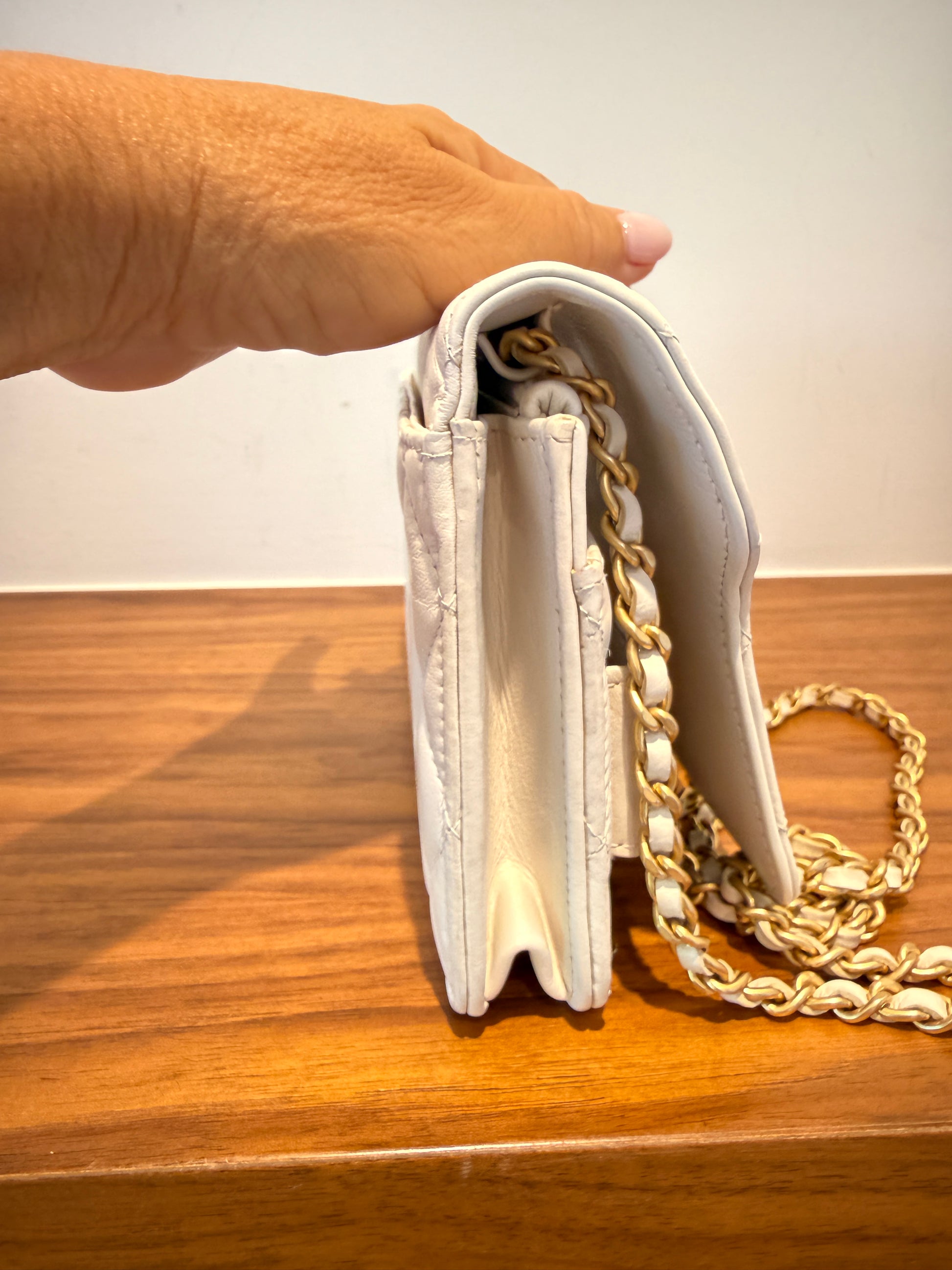 Chanel wallet on chain in white leather view of side of handbag