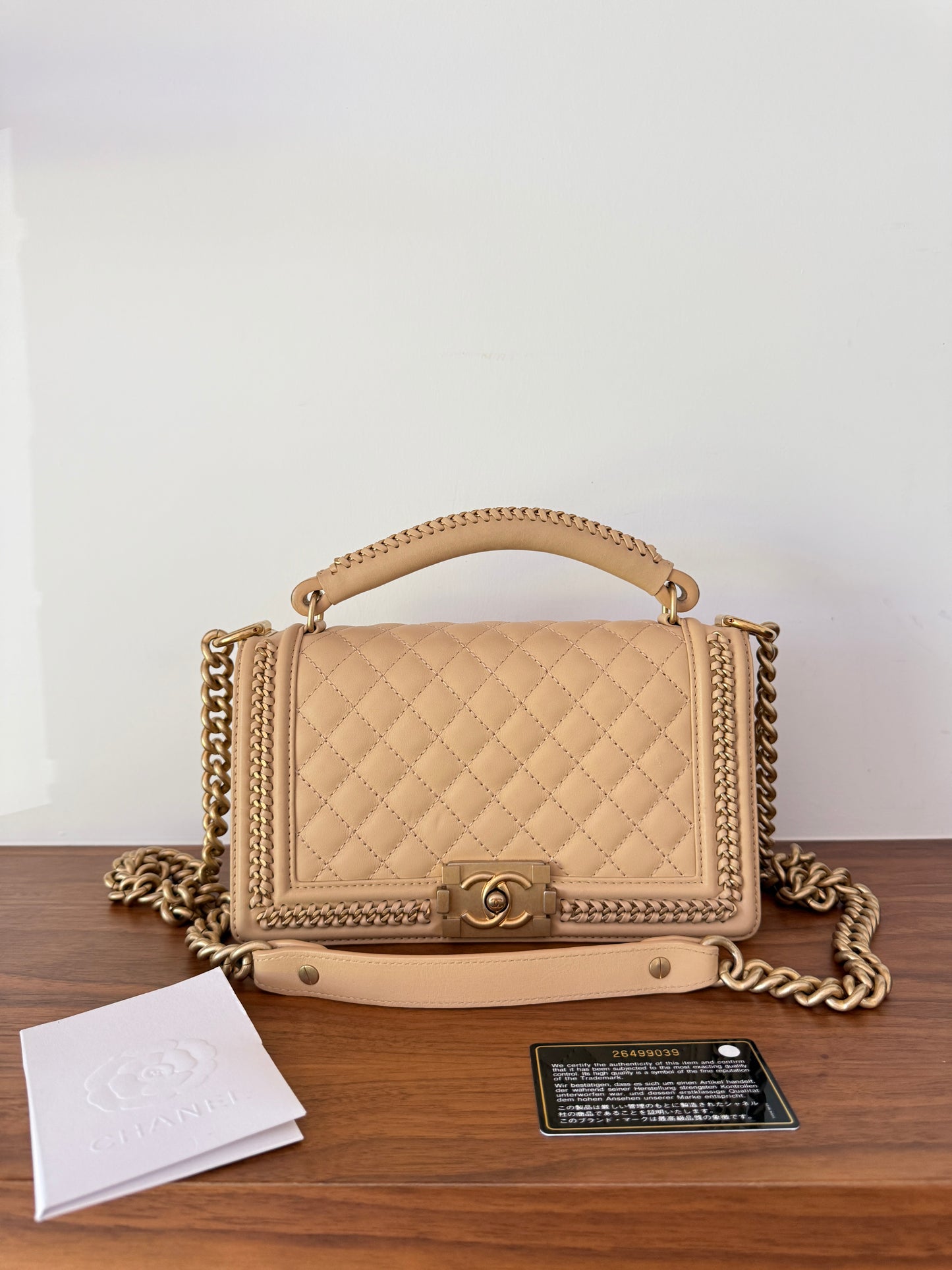 Chanel boy bag medium size beige shown with receipt and black card