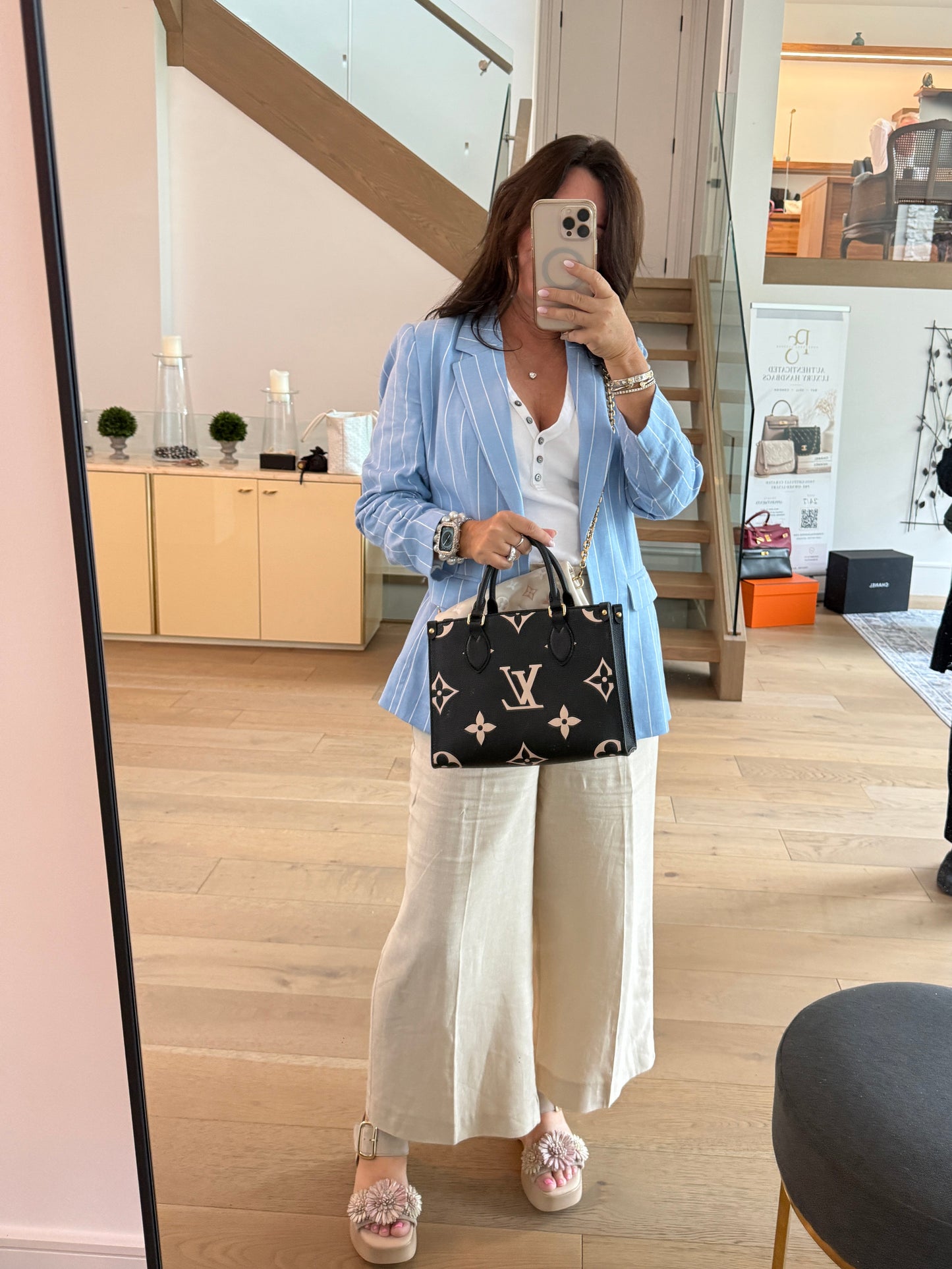Louis Vuitton On The Go PM in Black and Beige shown held by a woman by top handles