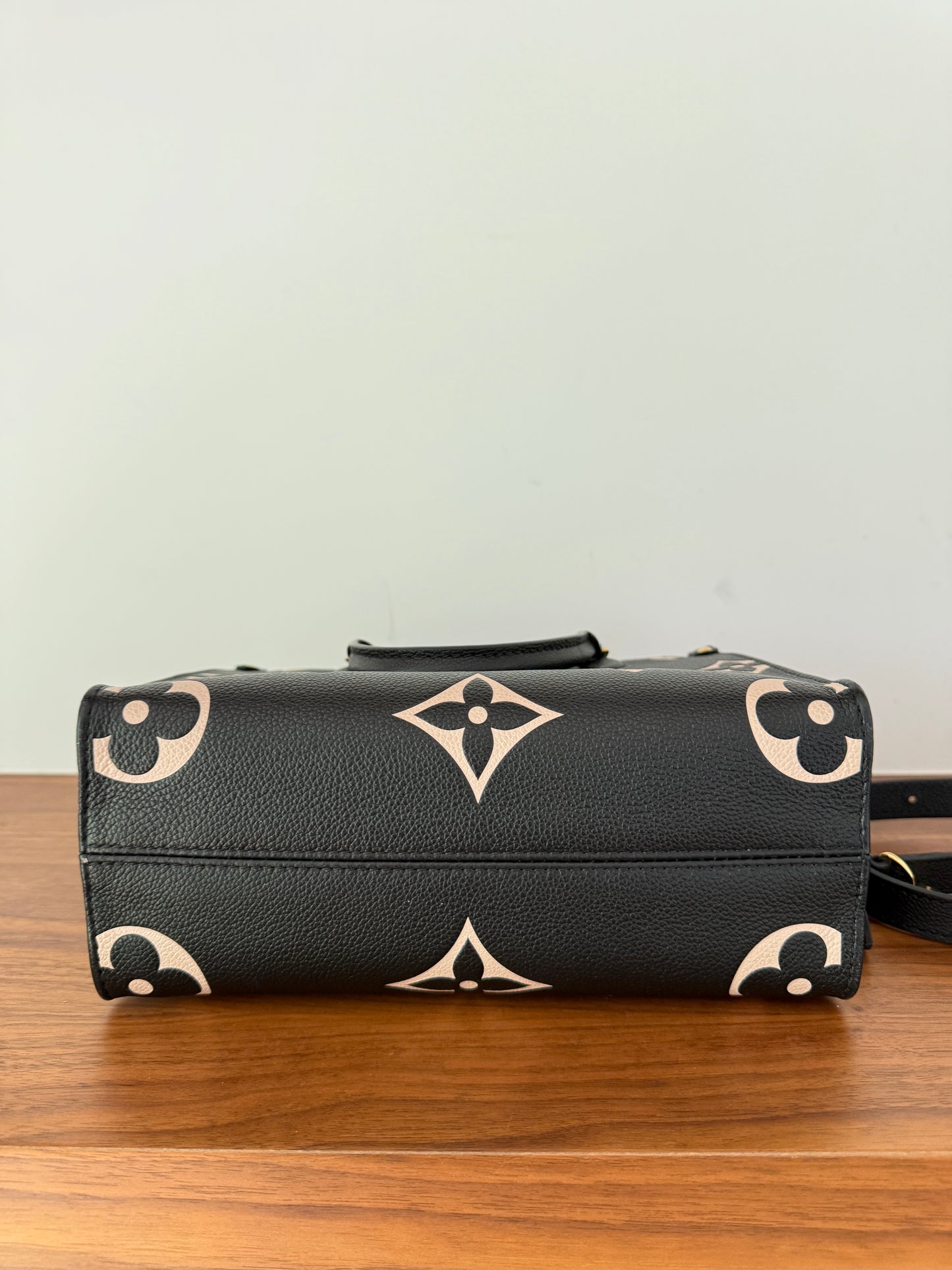 Louis Vuitton on the go pm size in black and beige photo of bottom of purse
