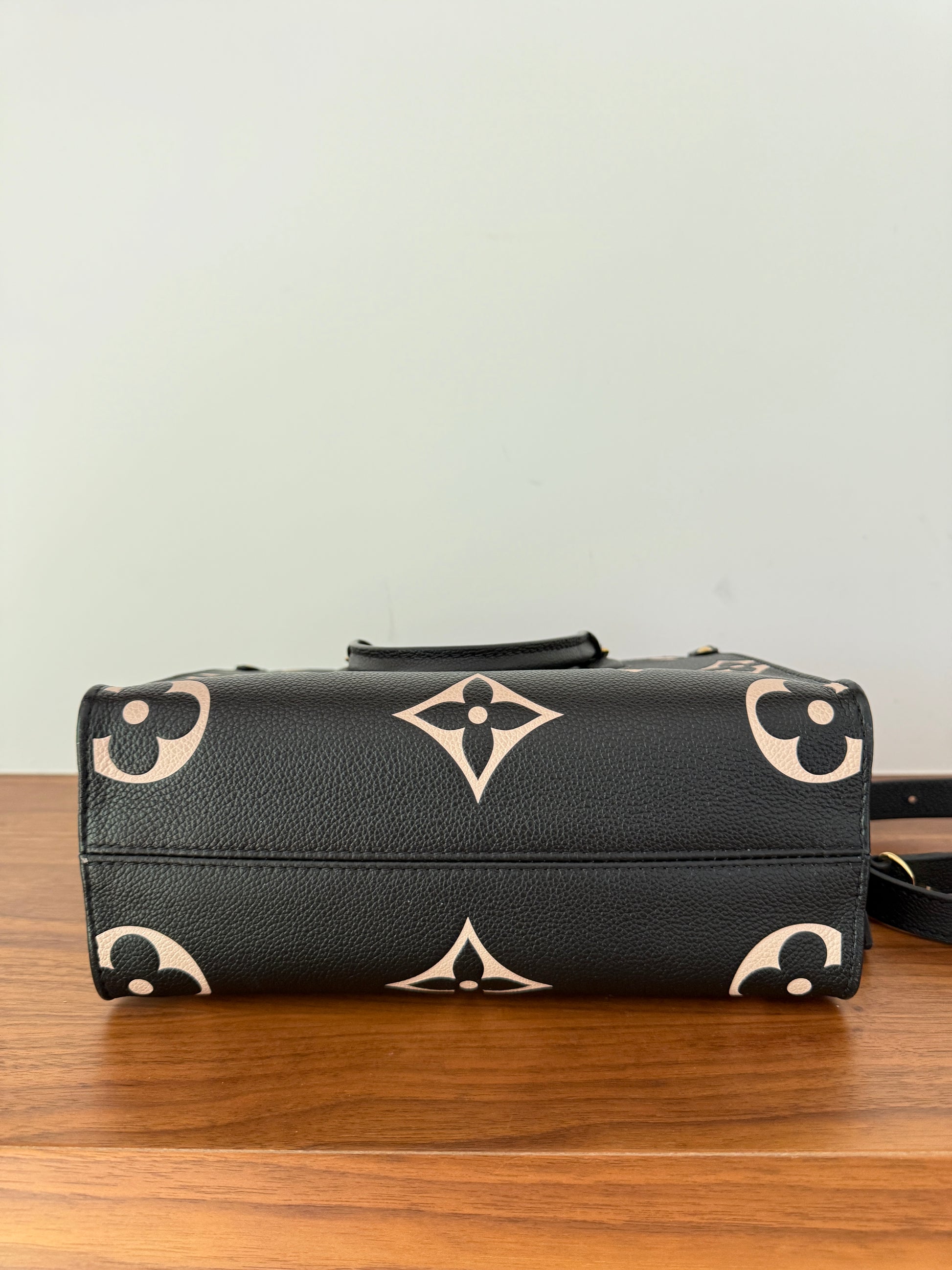 Louis Vuitton on the go pm size in black and beige photo of bottom of purse