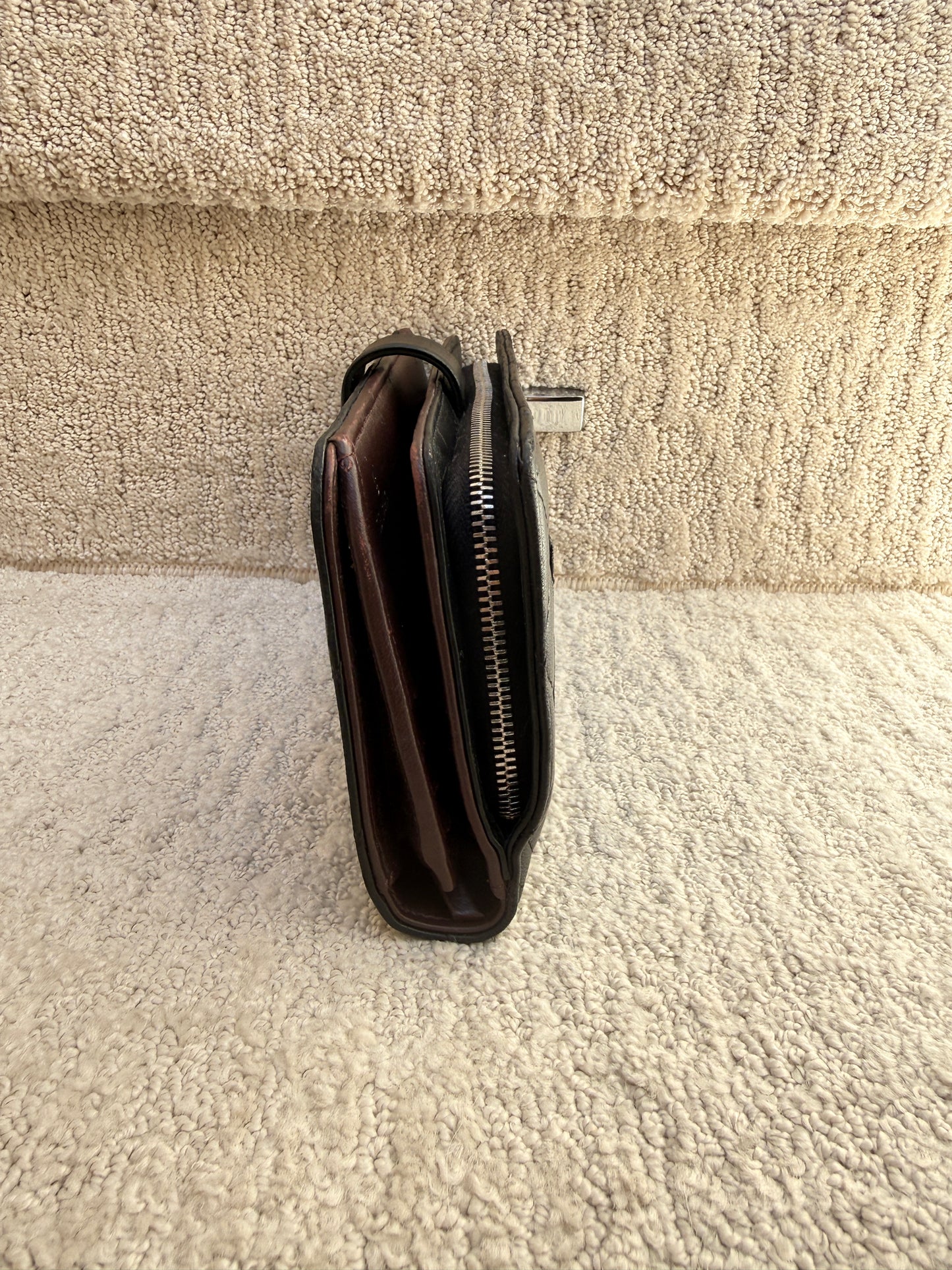 Side view of large chanel wallet with outside zipper and interior zipper and snap closure used and for sale