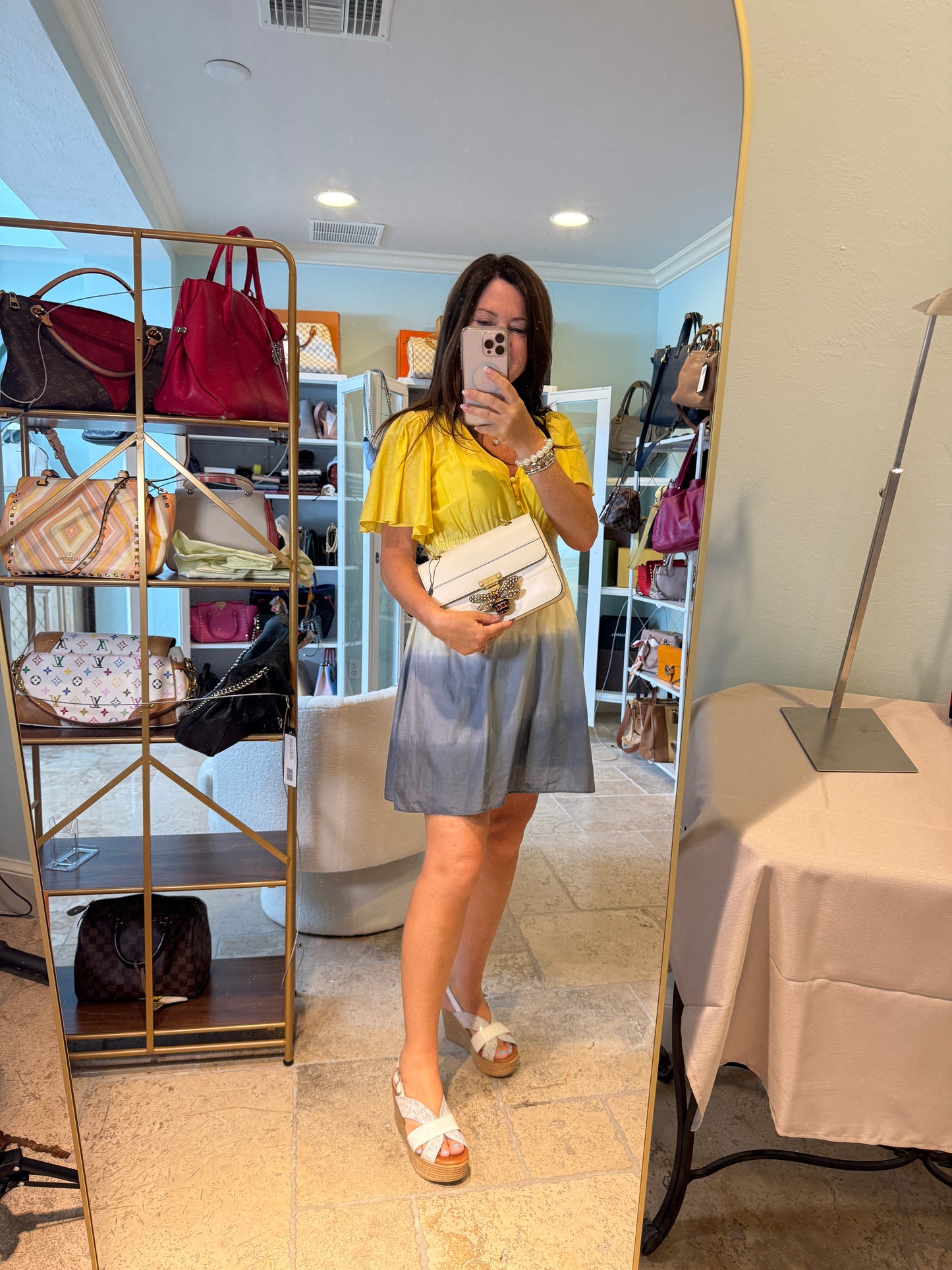 Gucci queen margaret handbag in white shown carried as a clutch on woman