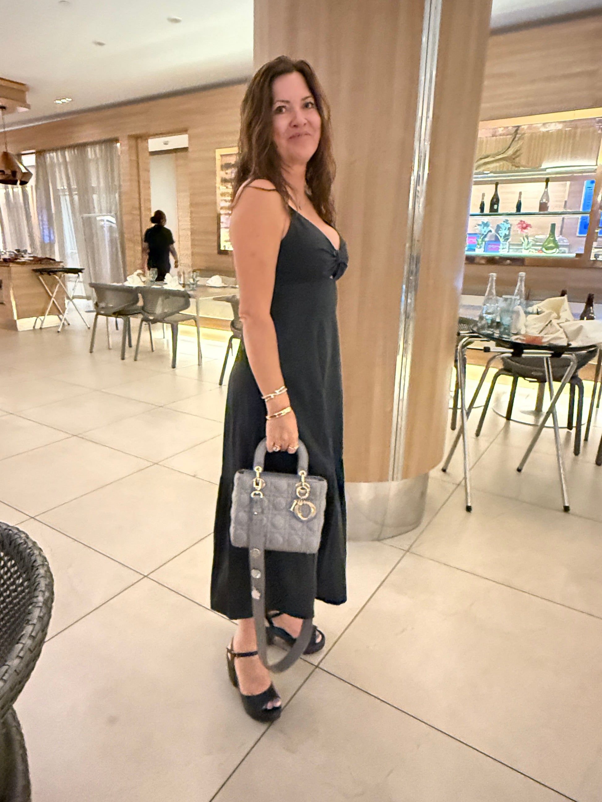 Christian Dior lady dior small handbag shown carried by 2 top handles by woman
