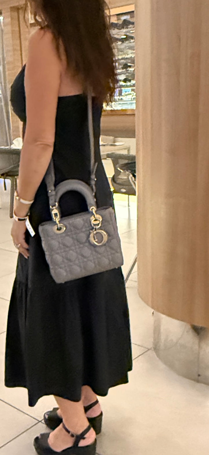 christian dior lady dior small handbag in grey leather shown worn as crossbody on woman