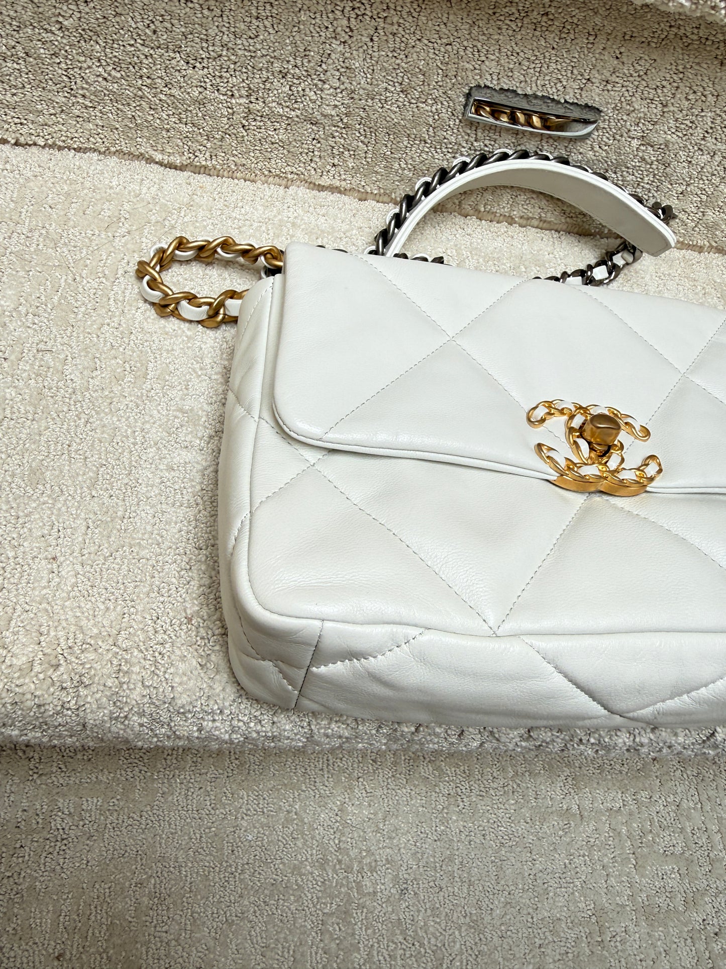 close up of front left corner of chanel 19 white leather handbag preloved
