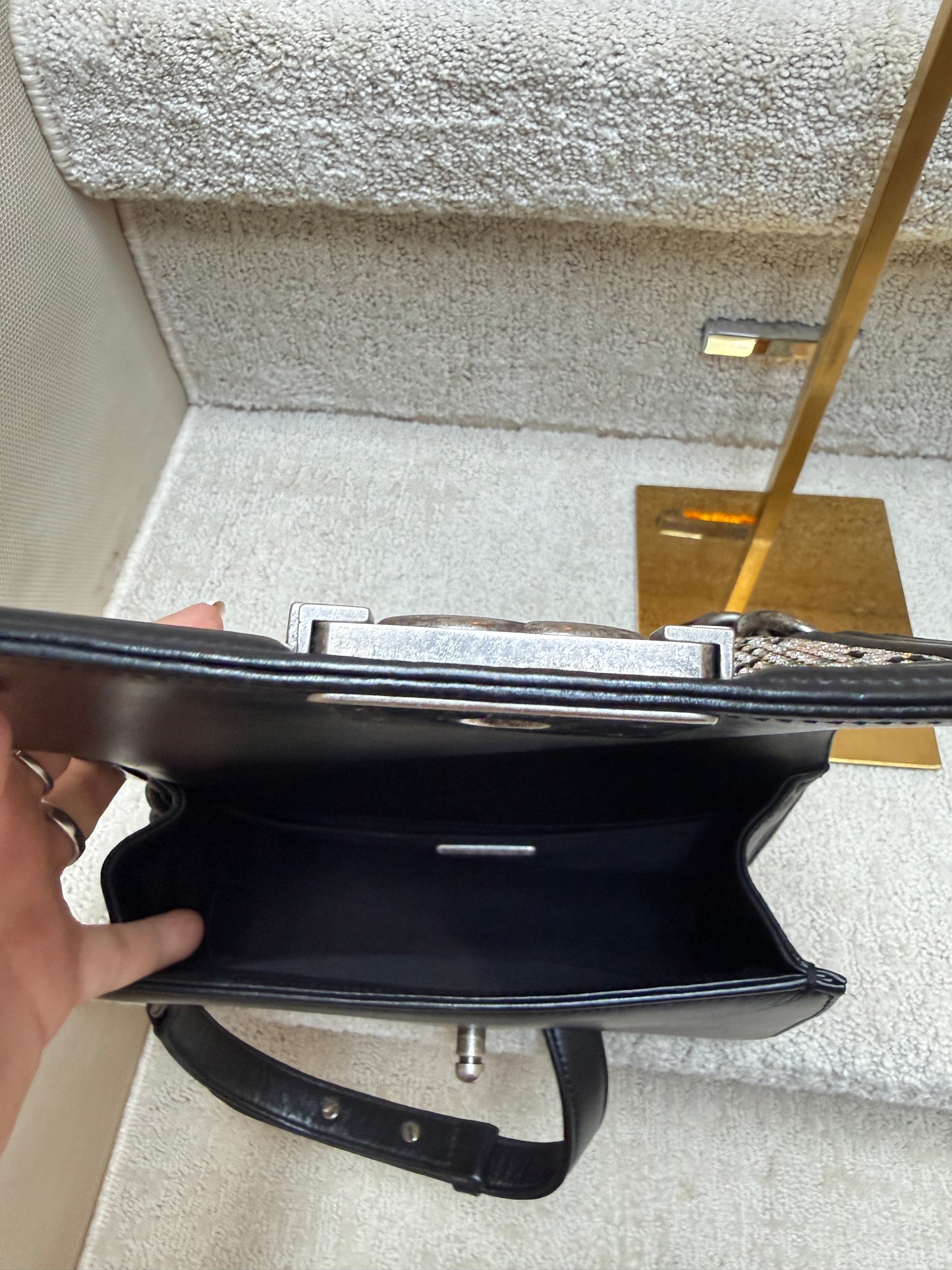 Black chanel boy bag small handbag held open to show clean interior.