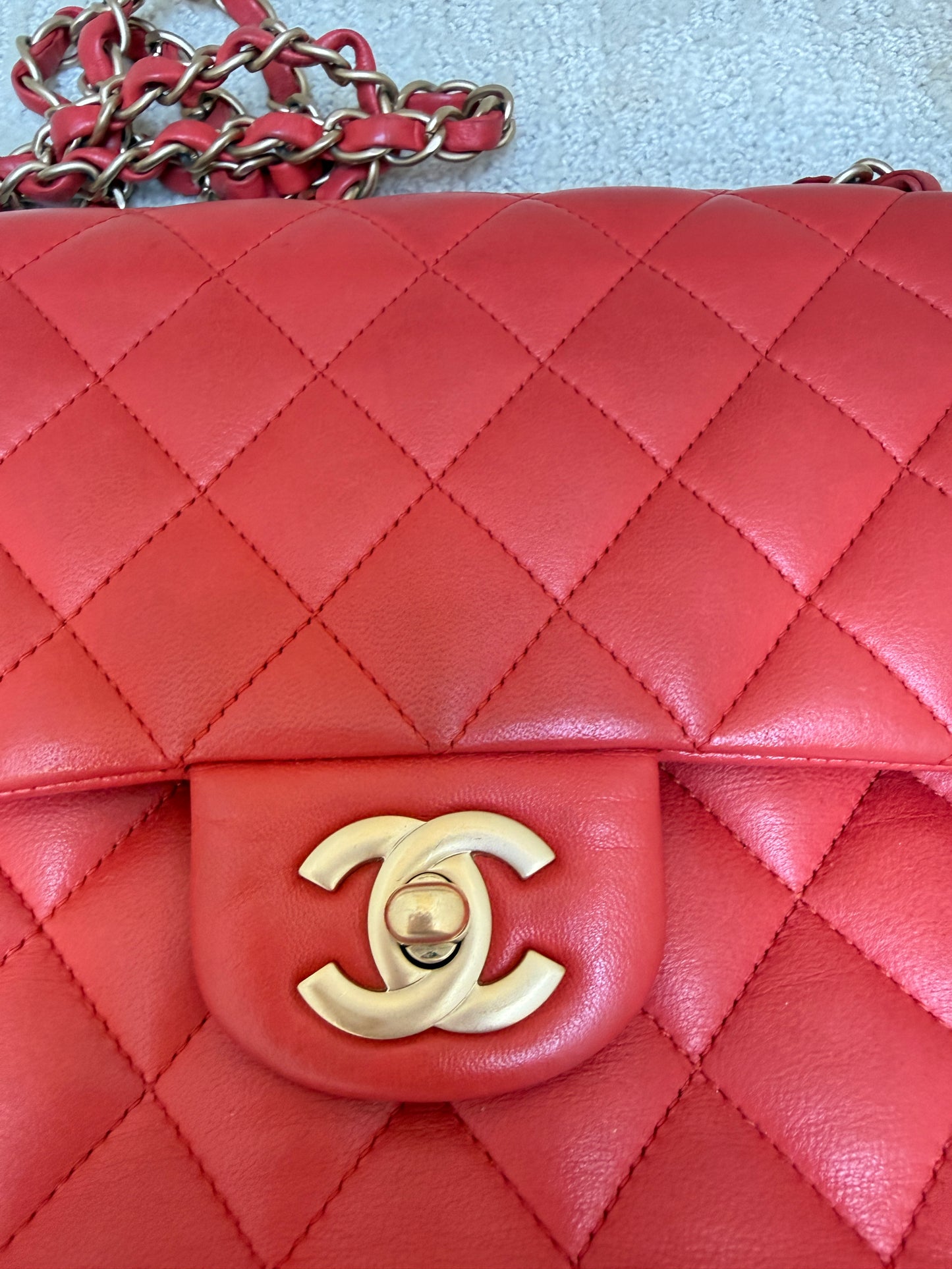 closeup of gold CC turn lock on chanel red classic flap in medium