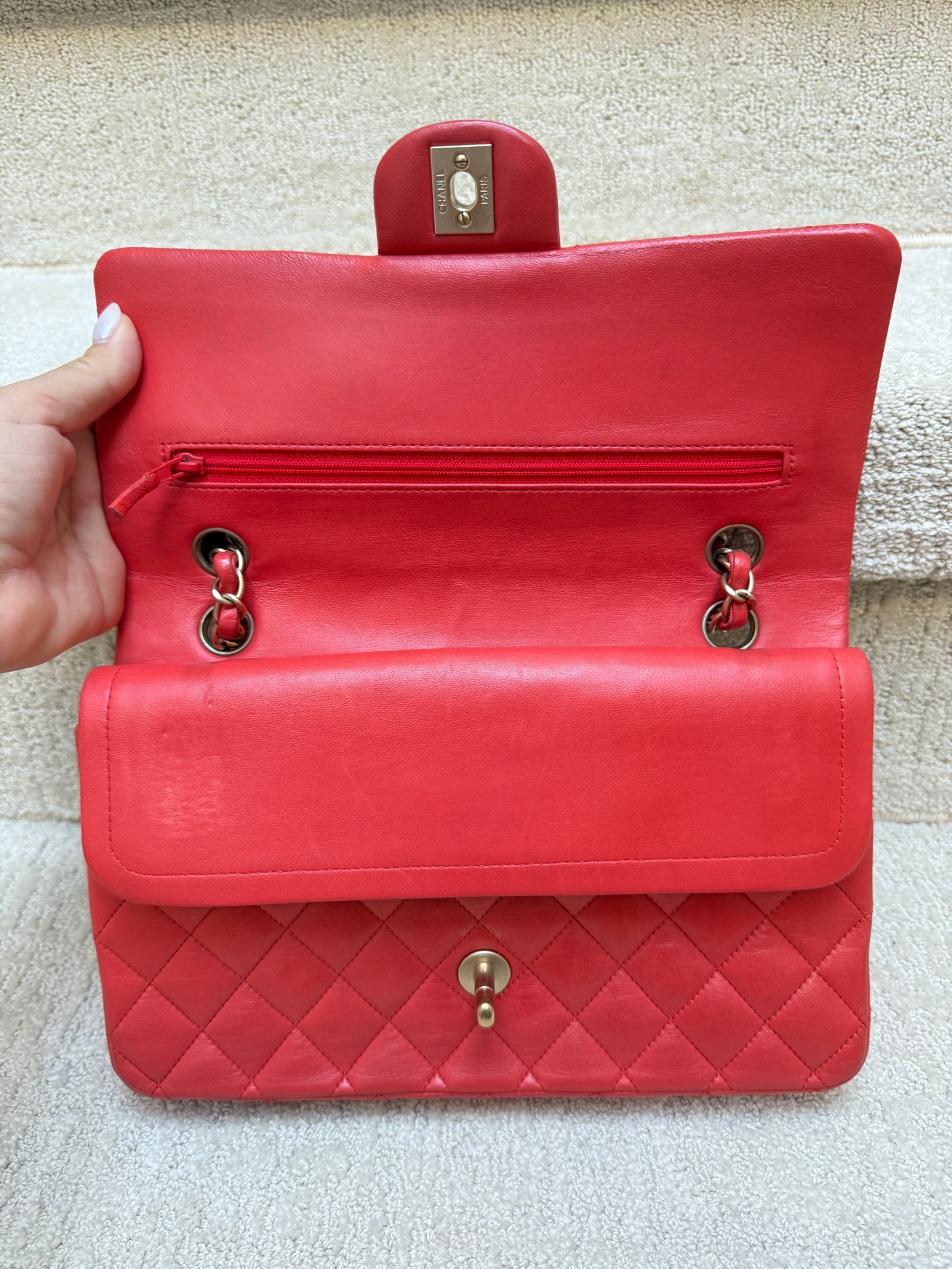 view of chanel classic double flap under first flap on red handbag