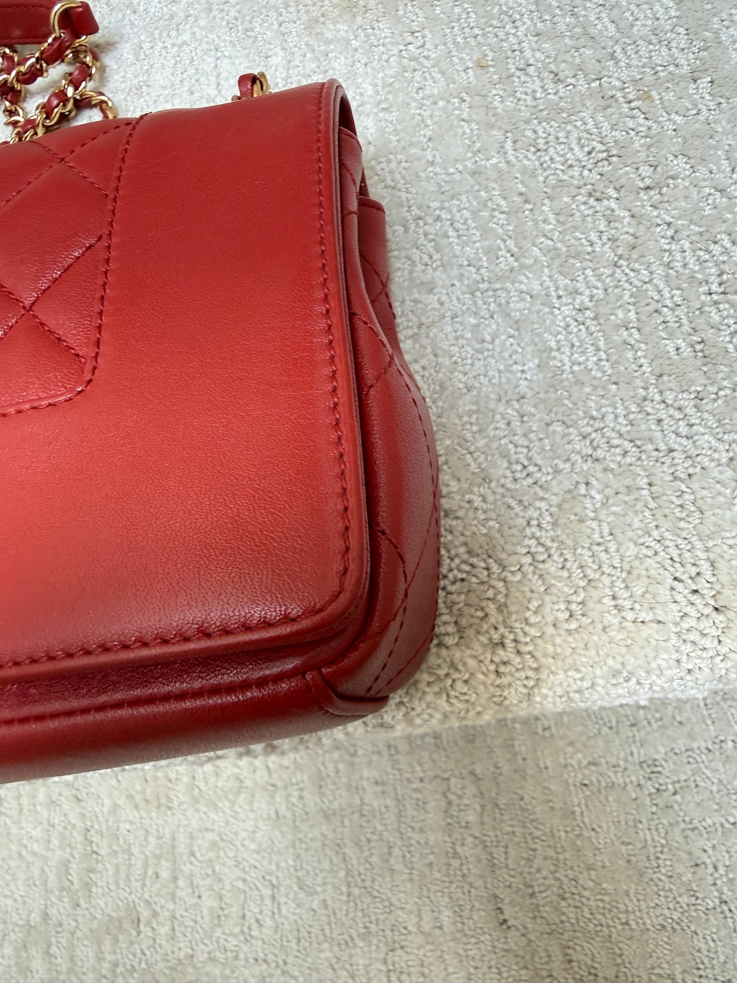 close up of front corner of chanel medium flap in red 