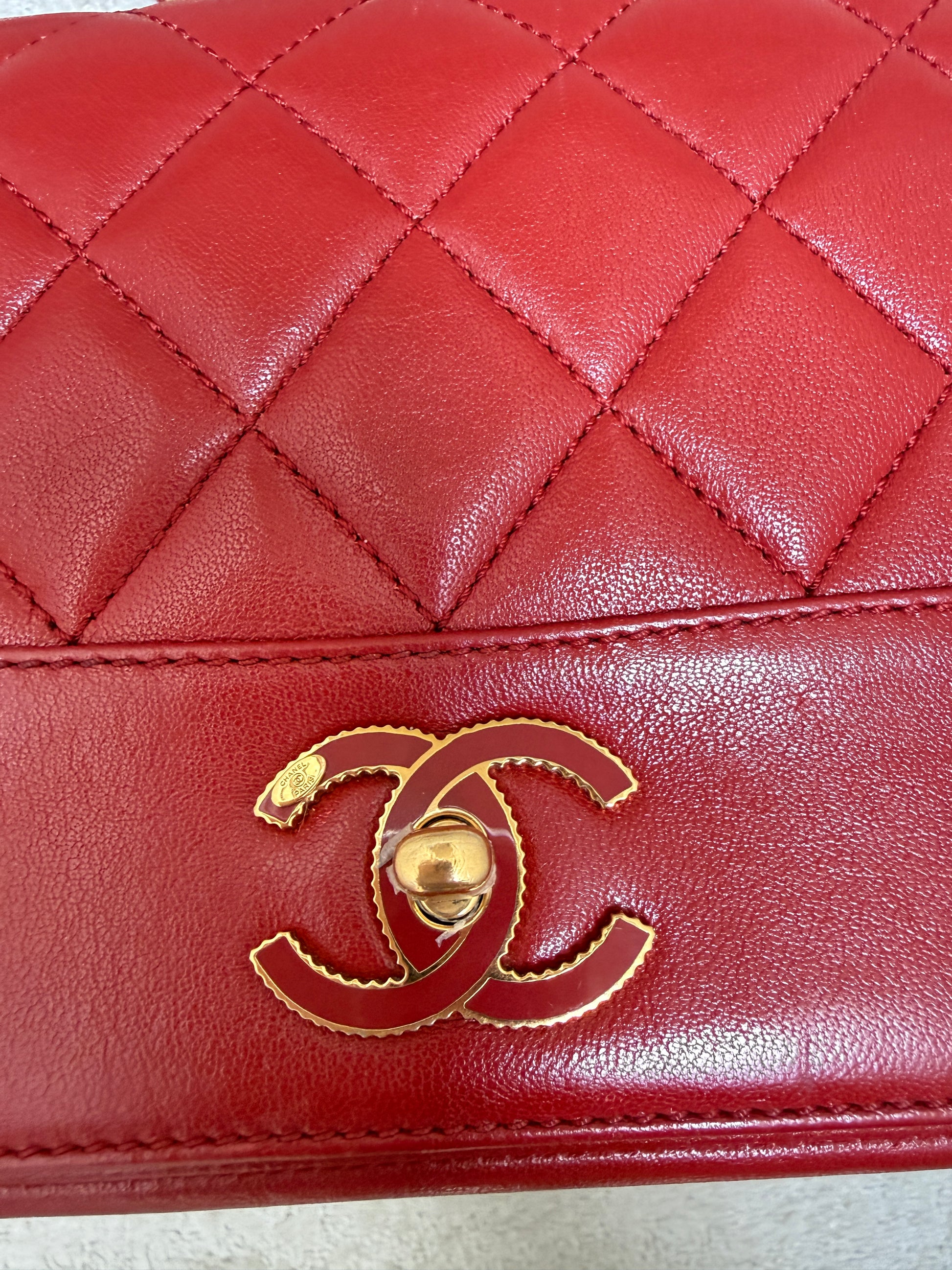 close up of CC turn lock on chanel mademoiselle medium in red and gold