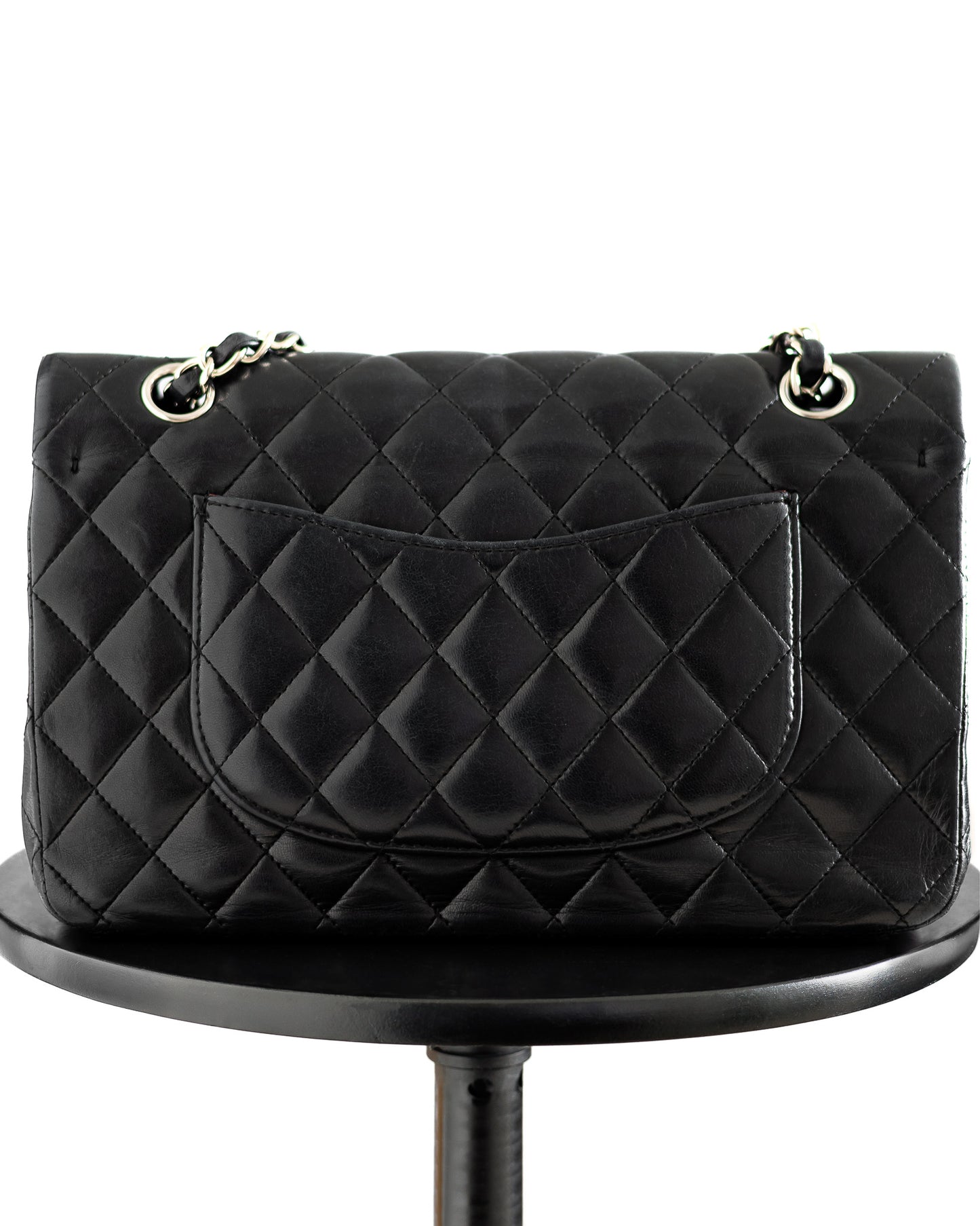 Chanel medium classic flap handbag showing back side offered for sale on resale market.