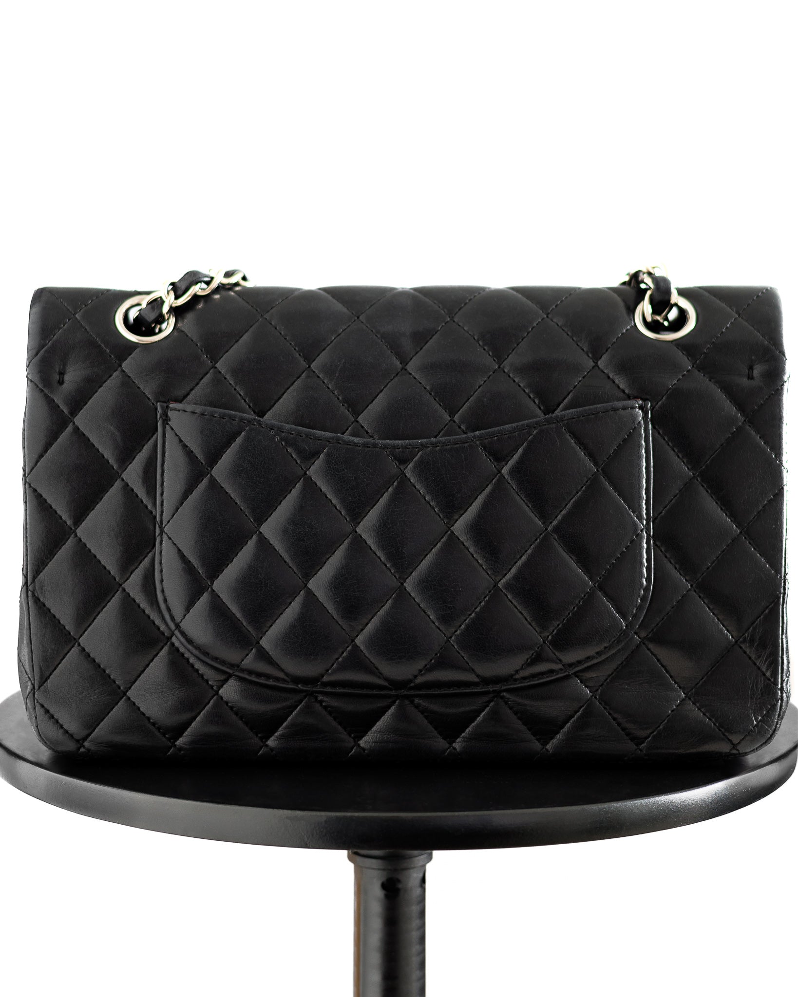Chanel medium classic flap handbag showing back side offered for sale on resale market.