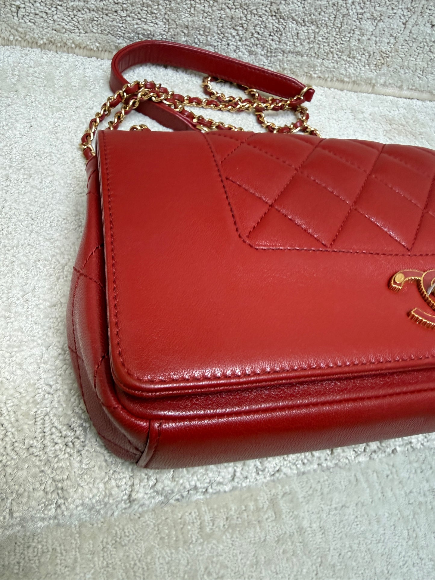 closeup of front corner of chanel medium flap in red leather