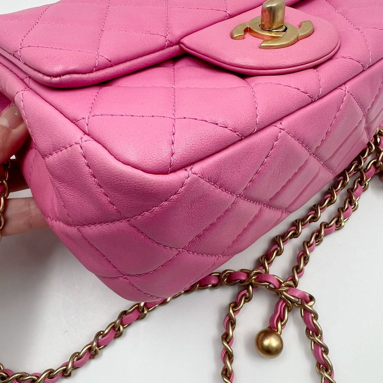 closeup of the corner of a chanel mini pearl crush square in pink lambsin