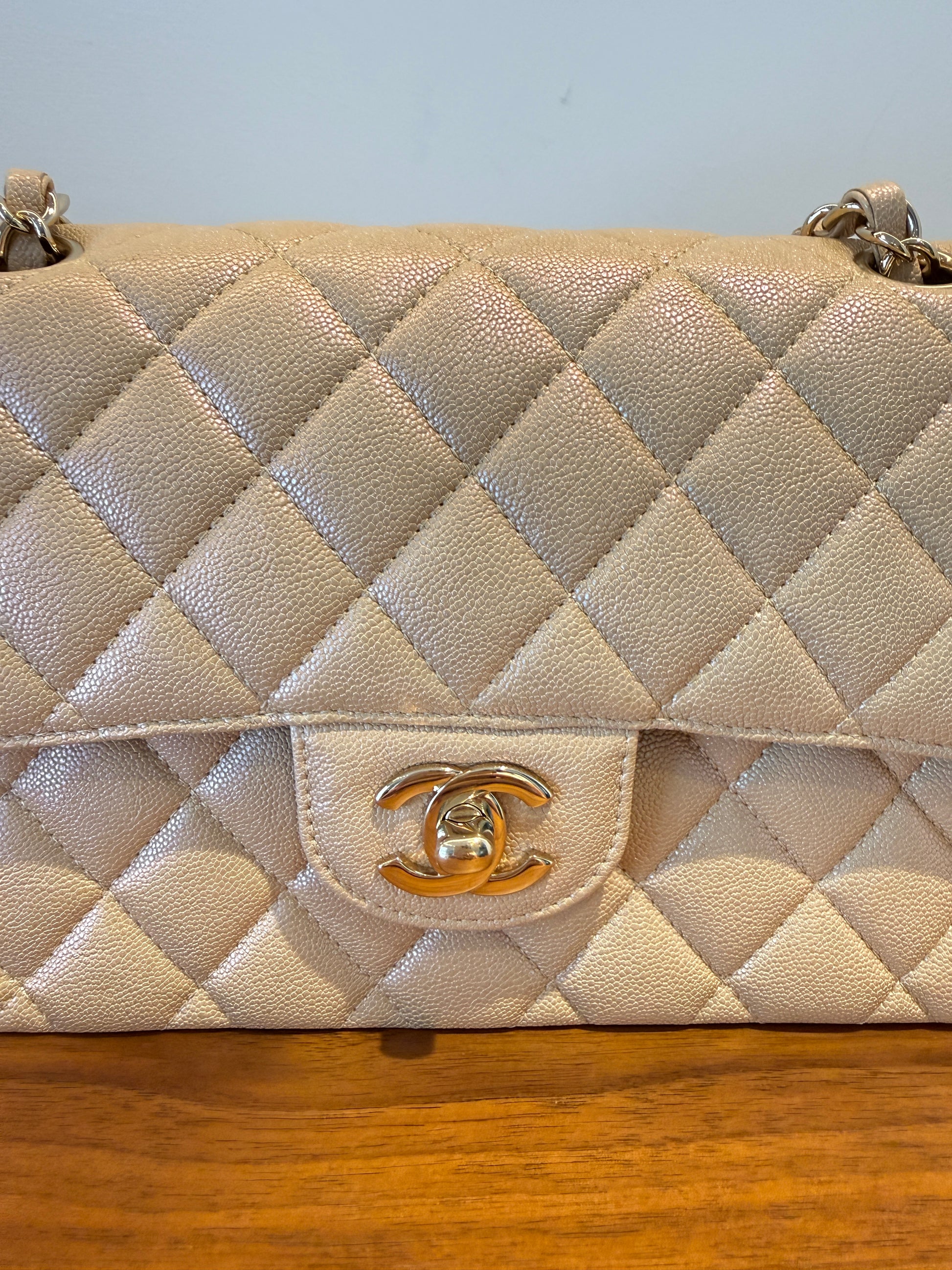 Chanel small double classic flap in beige caviar close up of gold cc 
turn lock