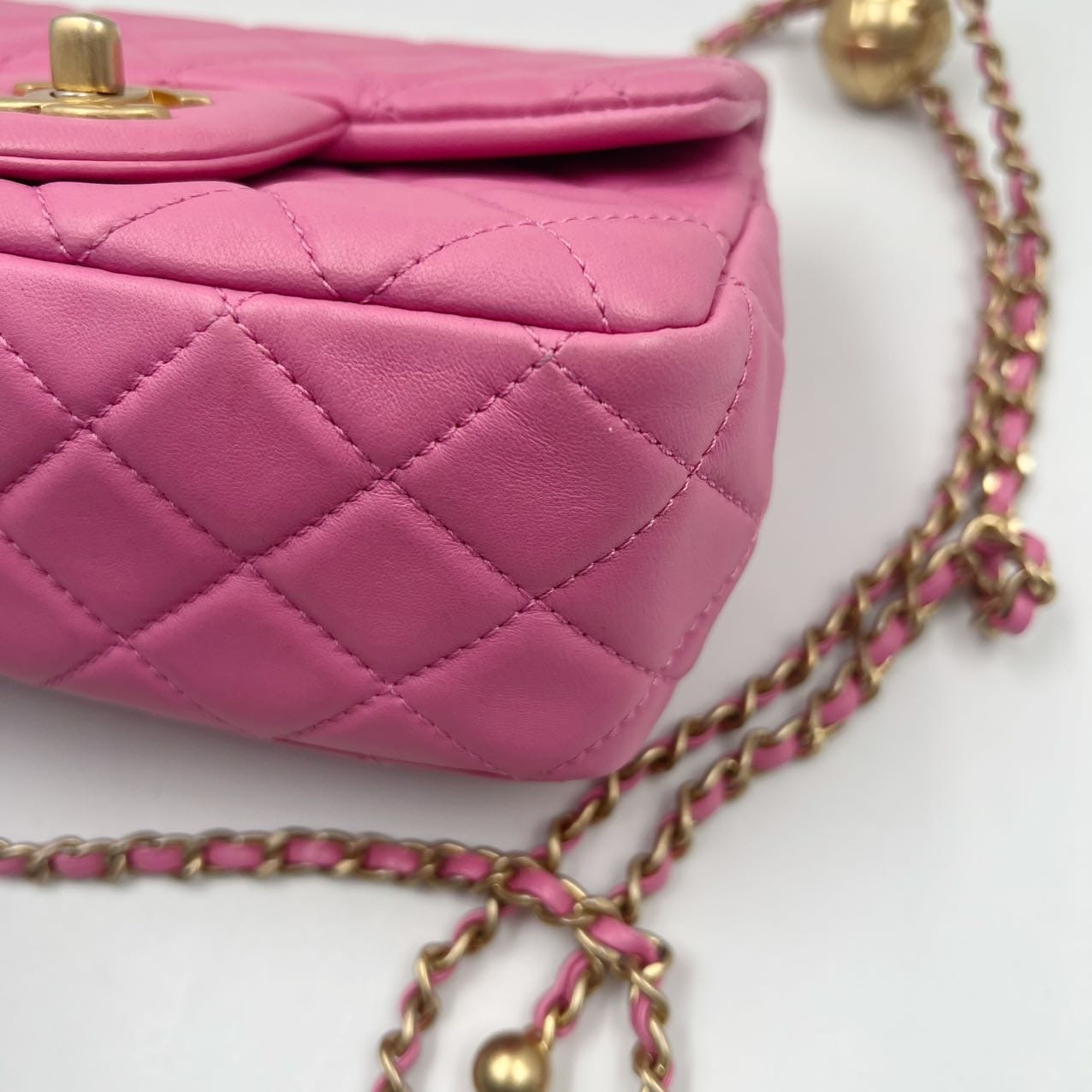 close up of the corner of a preloved chanel pearl crush in pink lambskin