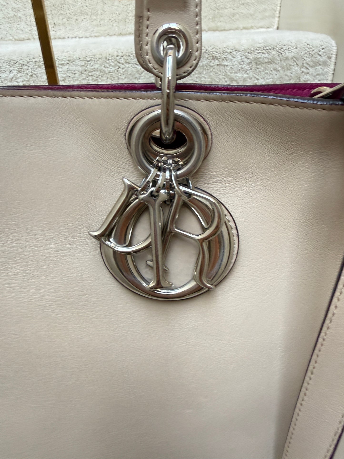 close up of dior charms on diorissima tote in beige leather with silver hardware resale 