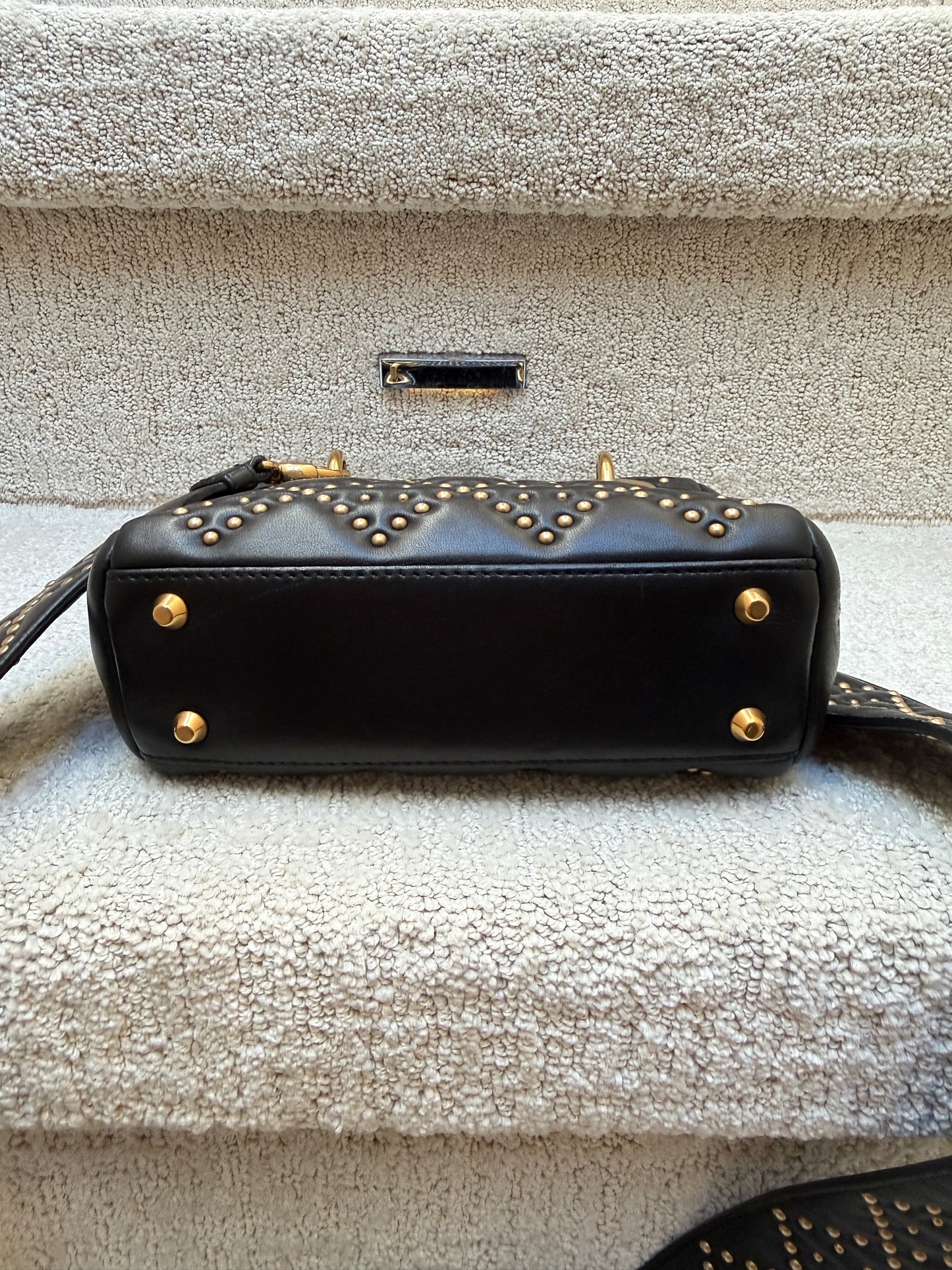 lady dior mini bag showing view gold feet on bottom of bag 
