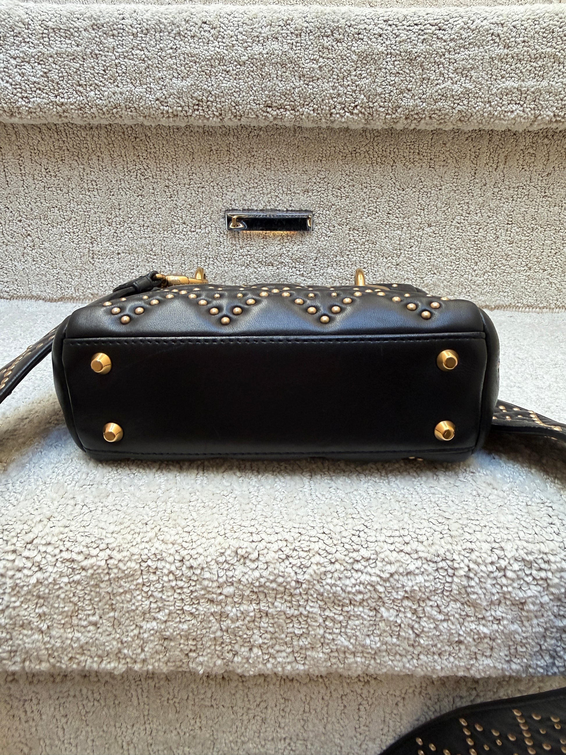 lady dior mini bag showing view gold feet on bottom of bag 