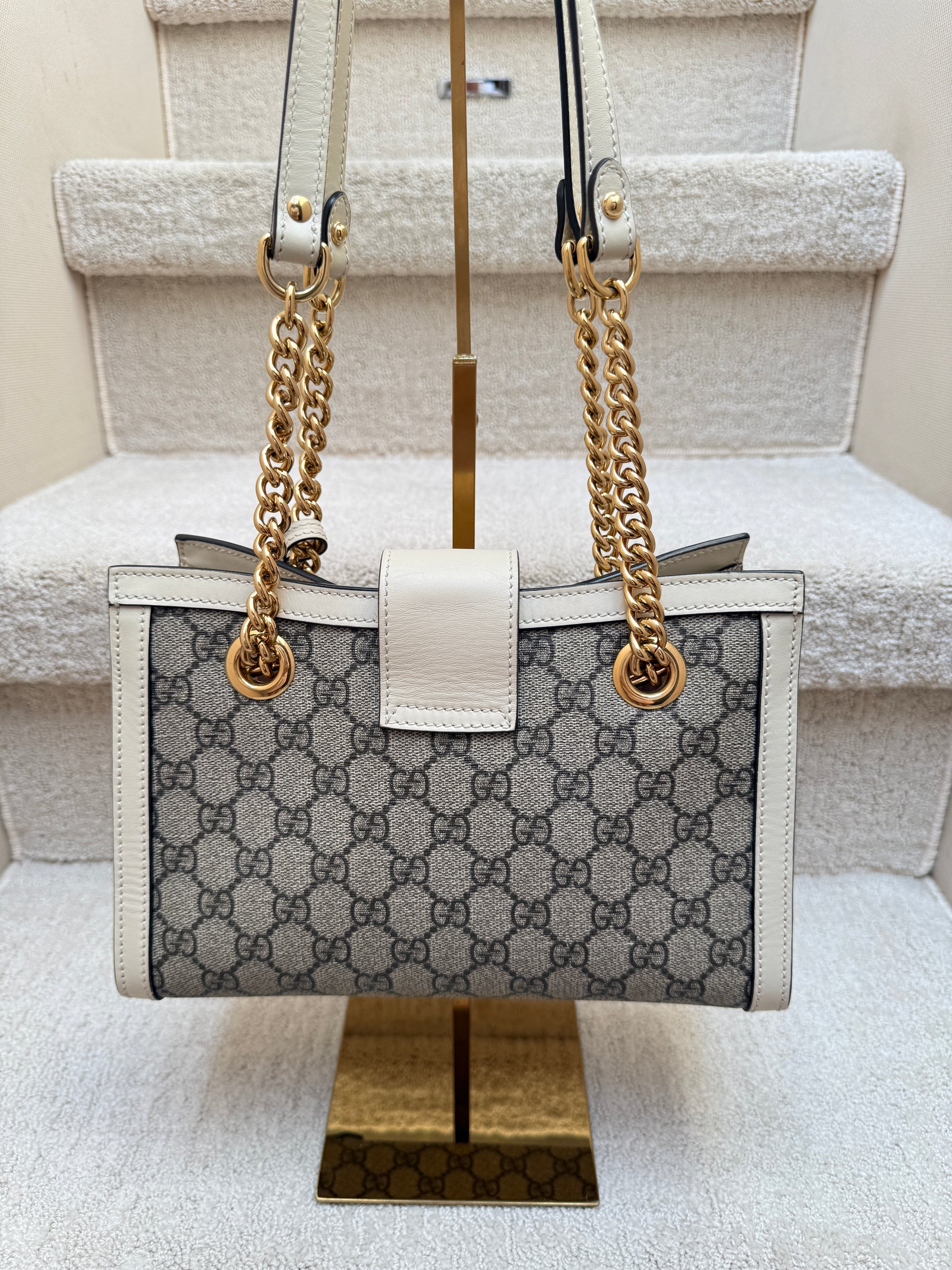 Gucci padlock supreme backside of purse showing excellent condition with gg monogram and white leather trim and gold chain handles