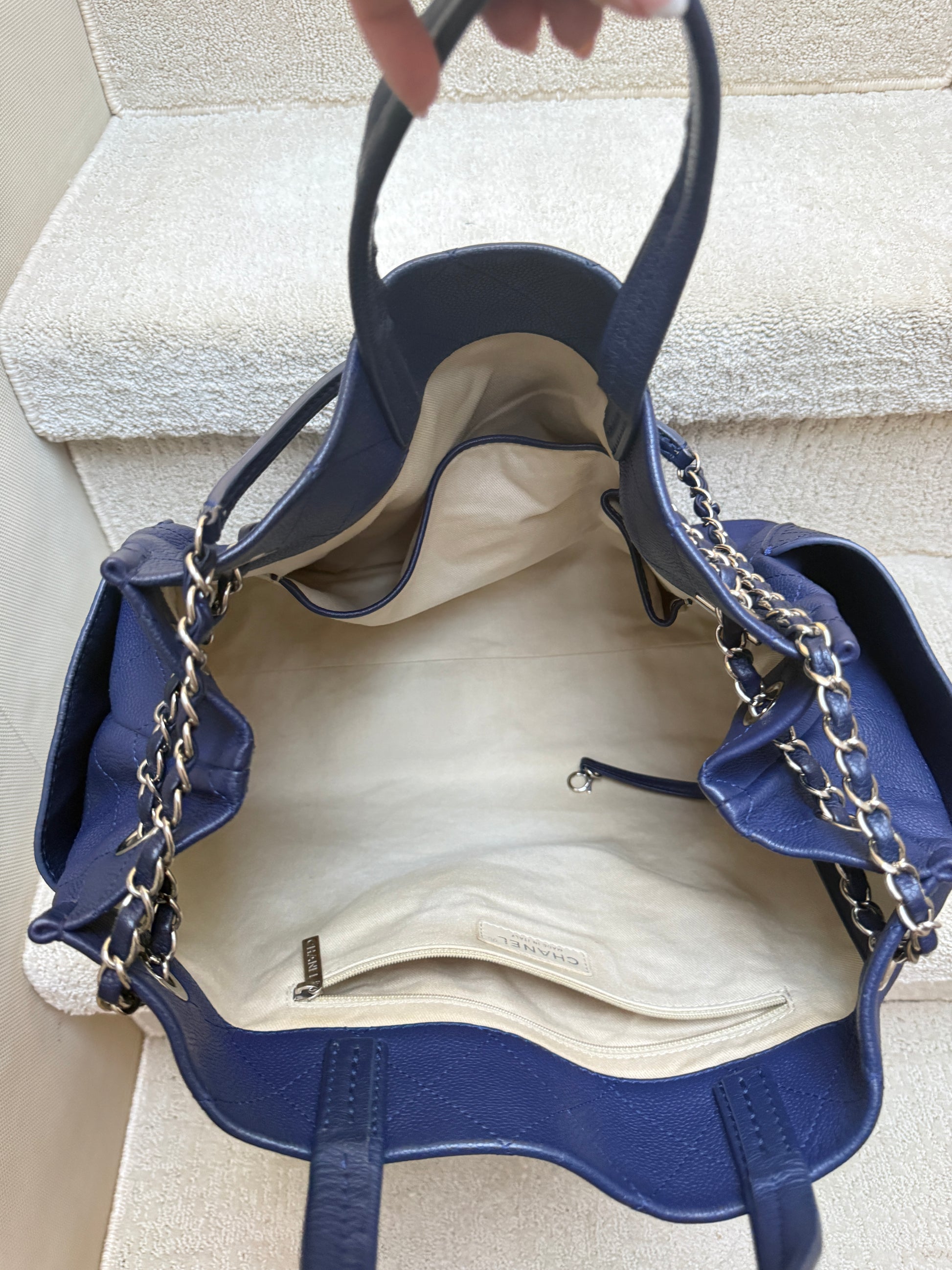 Chanel Blue handbag with beige fabric interior shown in photo with zipper compartment