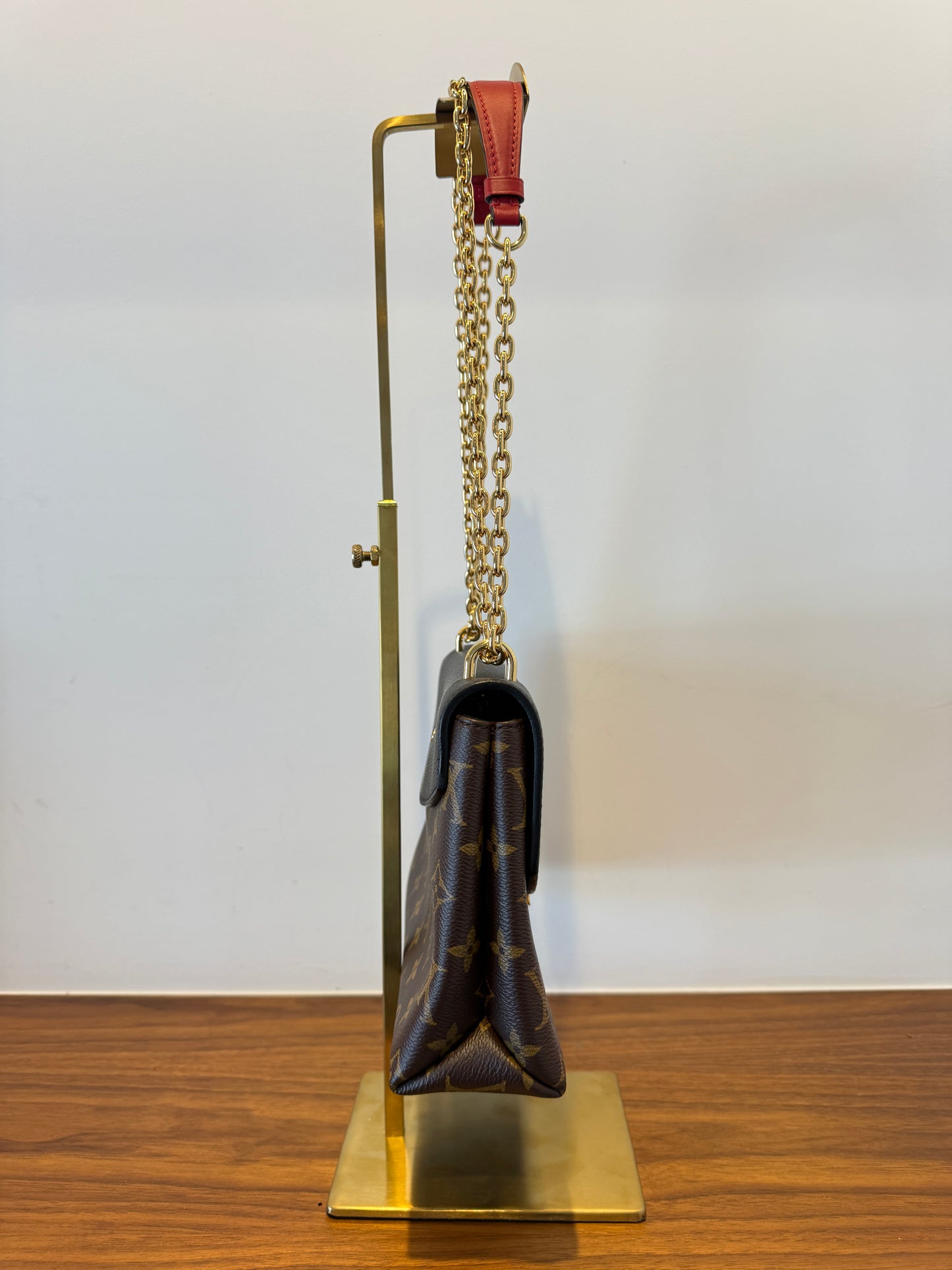 side view of louis vuitton saint placide in monogram and black with a gold chain