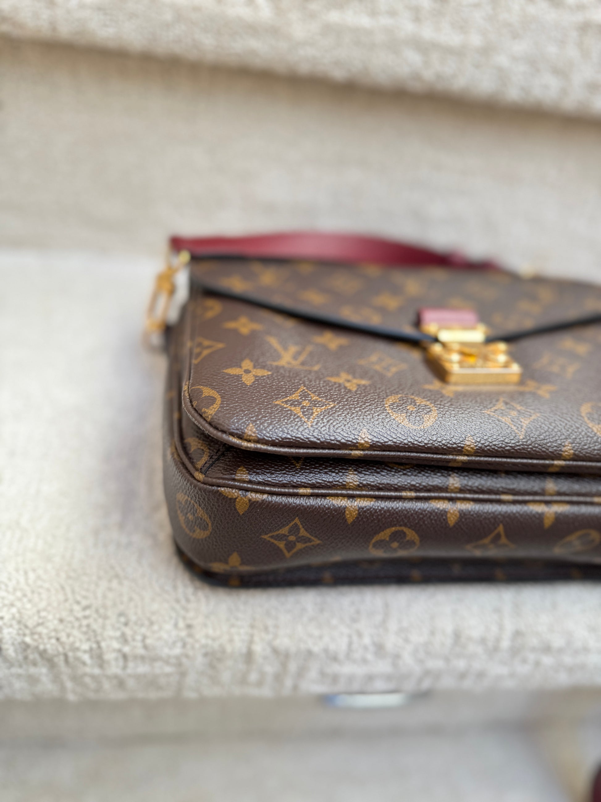 Louis Vuitton monogram handbag on a textured surface