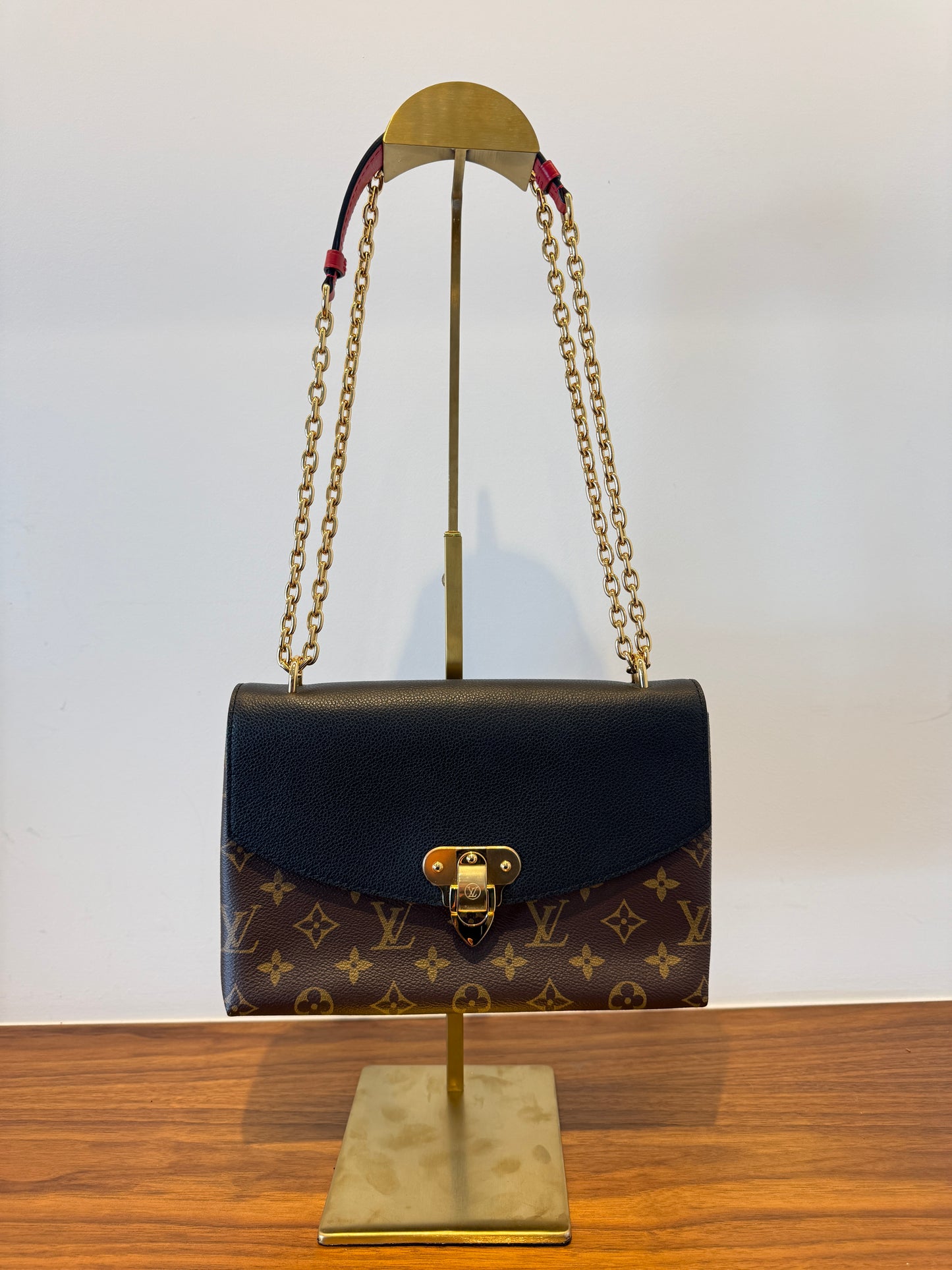 Front view of authentic Louis Vuitton Saint Placide Handbag in Monogram with Black flap and Red leather handle from purseonalshopper