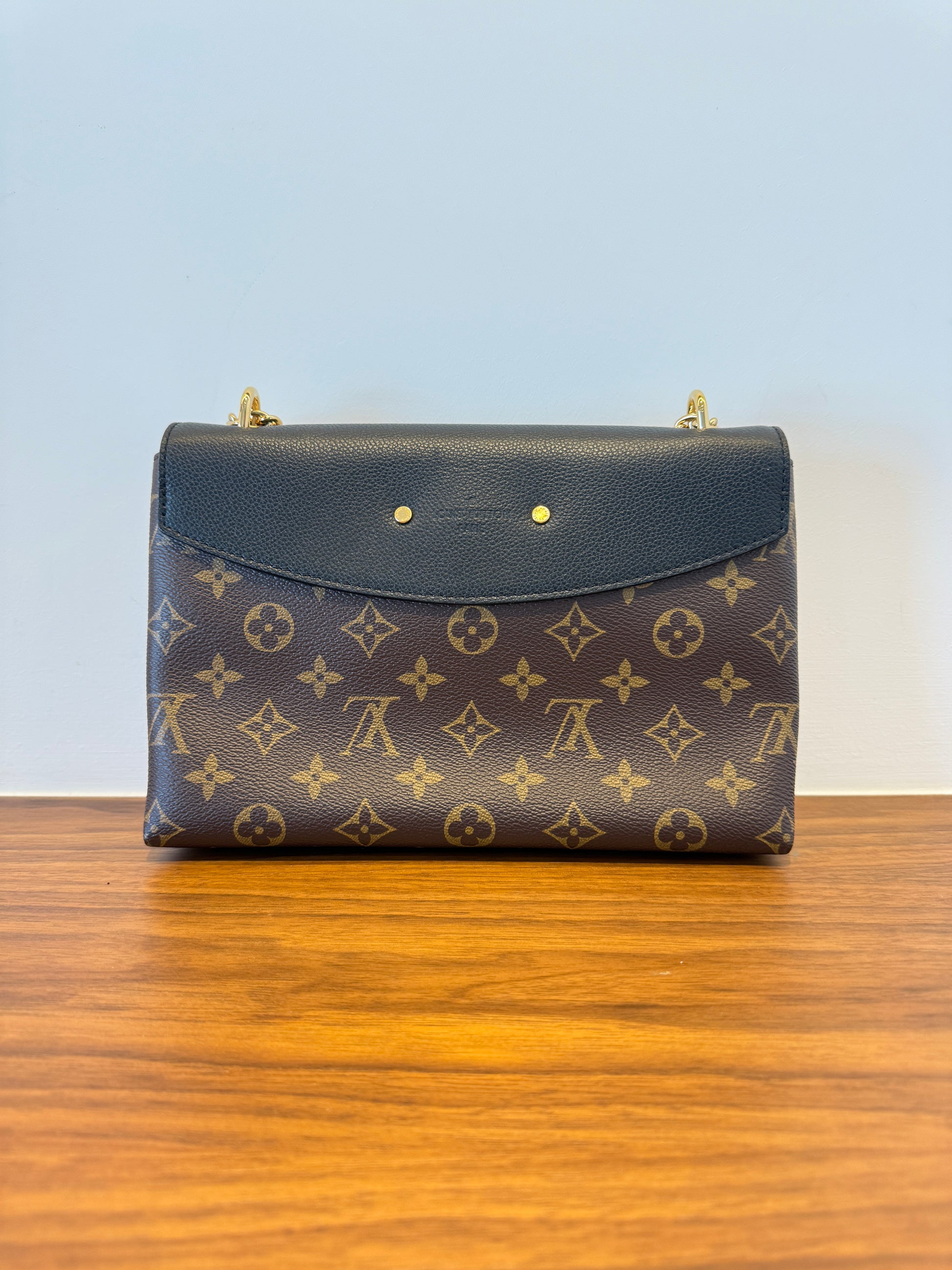 Rear view of louis vuitton saint placide monogram with black leather flap
