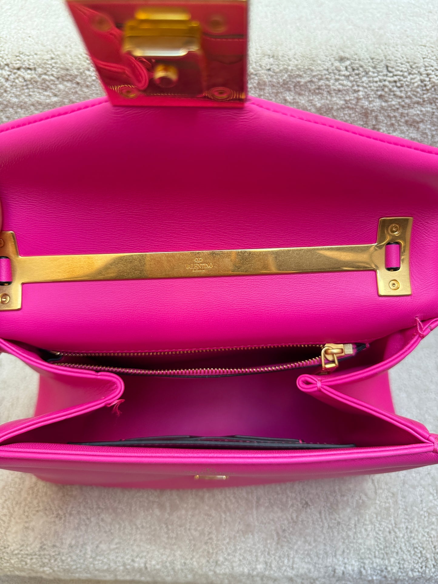Valentino one stud top handle handbag with a crossbody strap in bright pink showing interior view